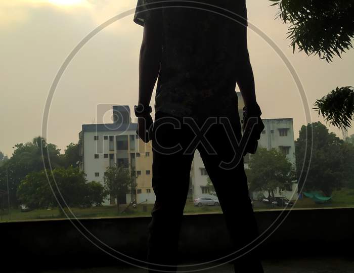 A boy standing in front of building , evening time