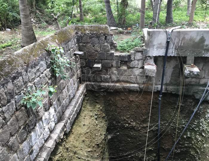 Water Well Used By Stone Boulders In Flemish Bond Construction For Agricultural Or Farming Purpose And Bucket Rope Facilities To Lift