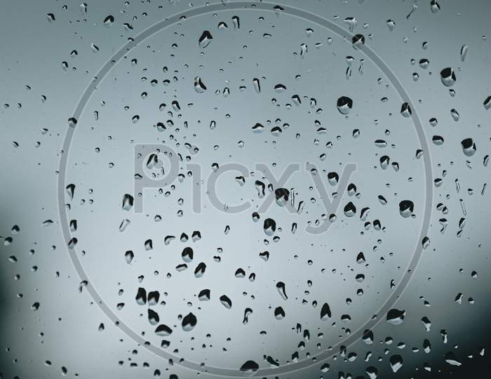 Vertical Background Of Some Moody Rain Drops Over A Window With Dark Tones And Textured Droplets