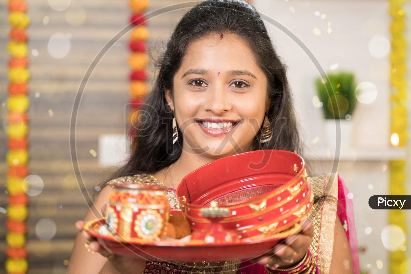 Close Up Pov Shot Of Indian Married Woman In Traditional Dress Holding Karva Chauth Thali Or Plate And Looking Into Camera During Indian Religious Karwa Chauth Festival.