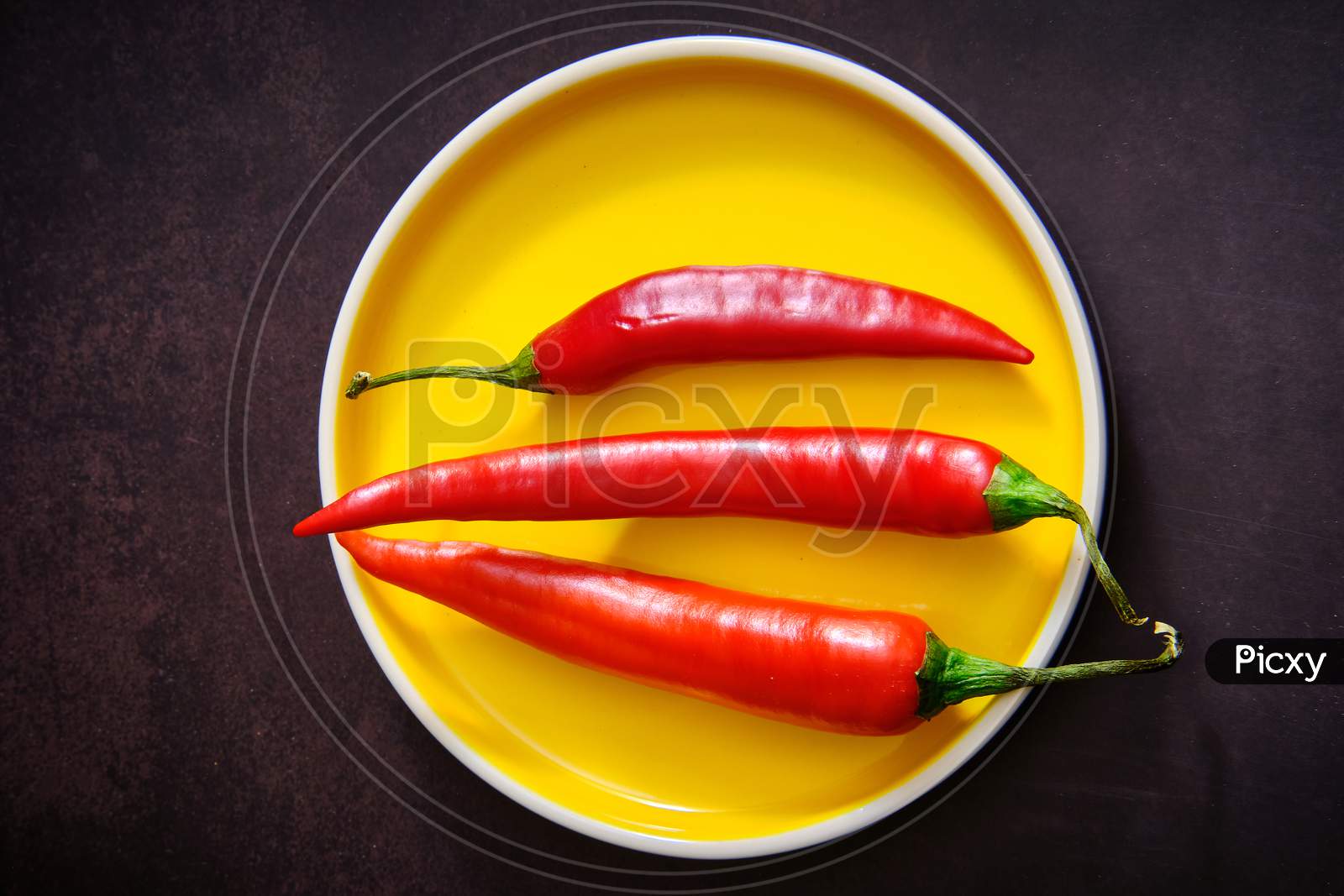 Red Chilli Pepper On Dark And Yellow Background