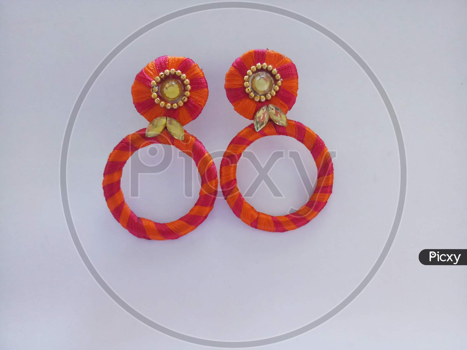 orange color home made earrings in a white background
