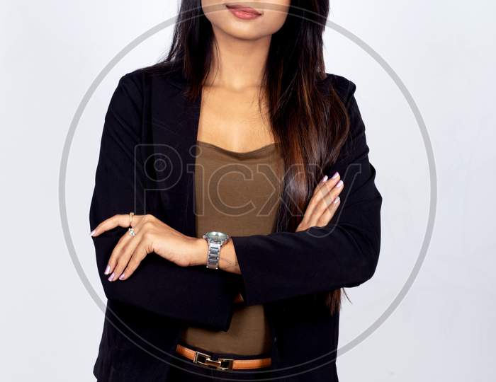 Confident young Indian businesswoman standing arms crossed on white background
