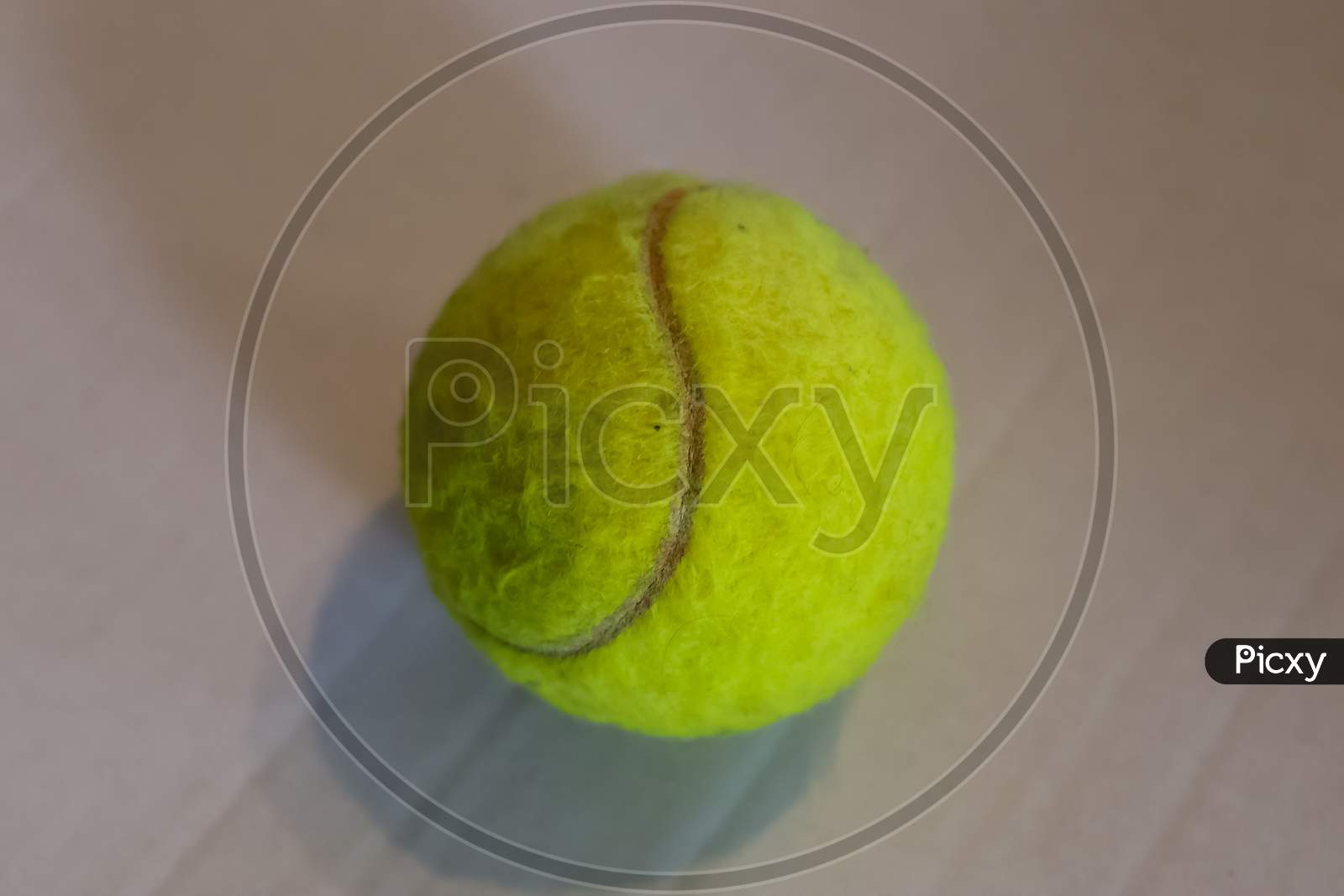 Colorful Tennis Ball In Front Of A White Paper Background