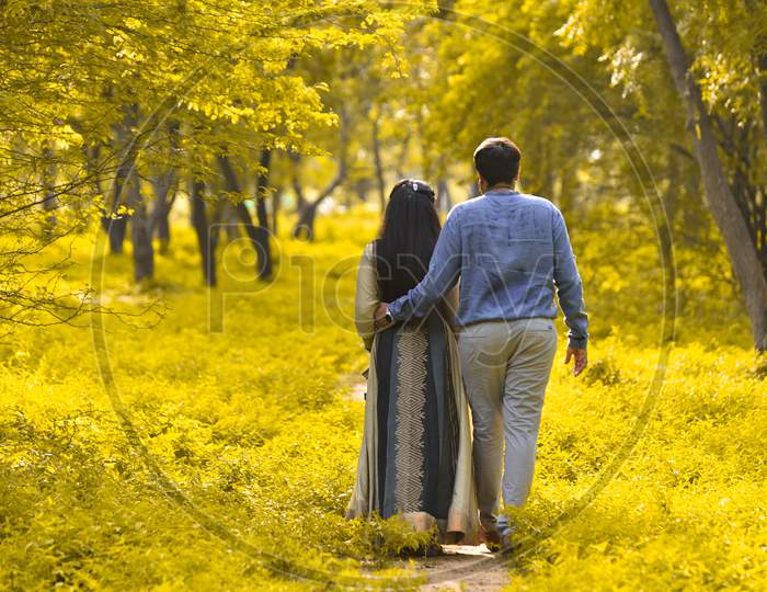 Young Couple Walk In Park To Take A Fresh Air .