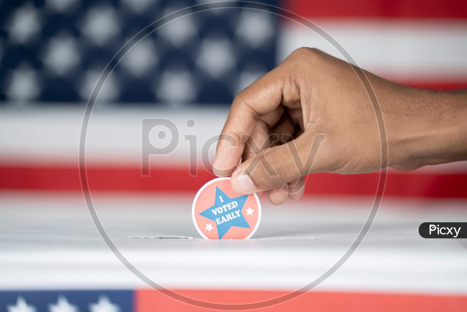 Close Up Of Hands Placing I Voted Early Sticker Inside The Ballot Box - Concept Of Early Voting In Us Election.