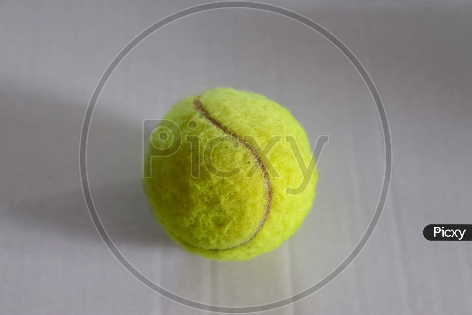 Colorful Tennis Ball In Front Of A White Paper Background