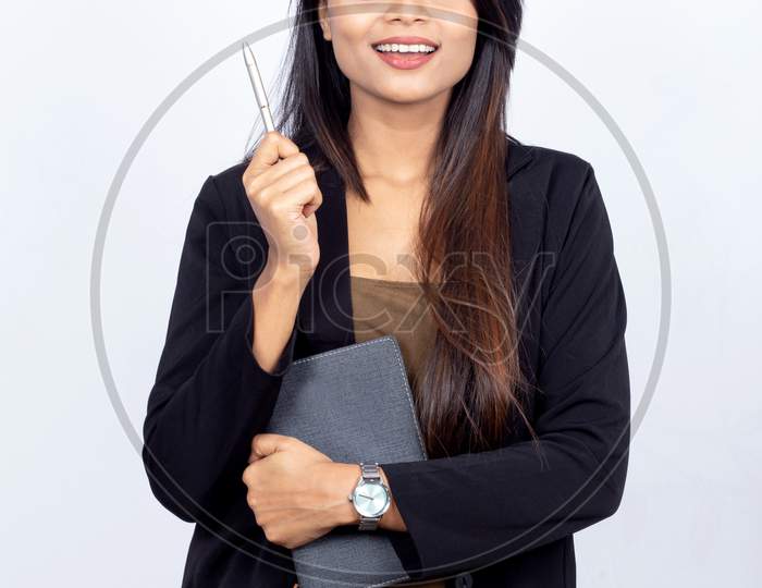 Indian businesswoman think something while holding diary and pen