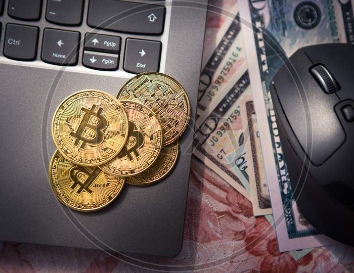 Top View Of Bitcoin Gold Coins On Laptop And Next To Us Dollar Banknotes And Computer Mouse