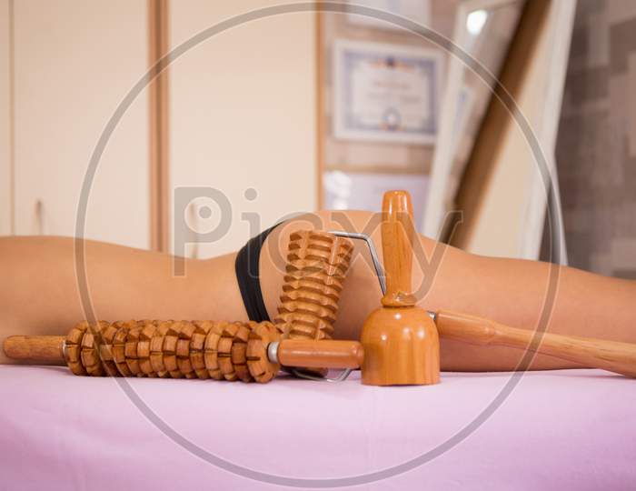 Hot Girl On The Massage Table Next To Her Is Wooden Massage Tools For Maderotherapy.