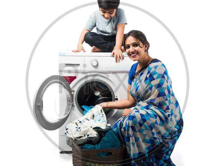 Indian Asian Woman In Saree Using Washing Machine With Kids