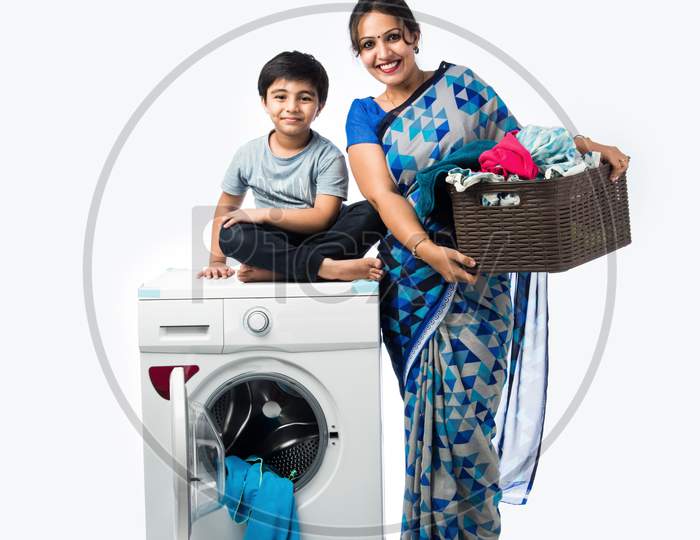 Indian Asian Woman In Saree Using Washing Machine With Kids