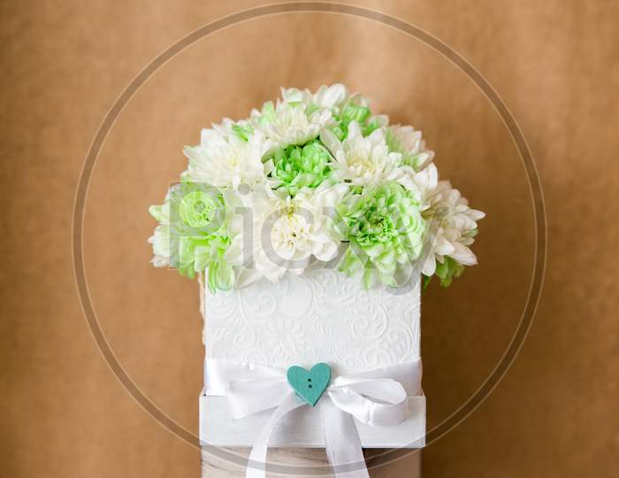 Close-Up On A Floral Arrangement Of Chrysanthemum Flowers. The Chrysanthemums Are White And Green And Are In A Hand-Made White Box. A Great Gift For A Loved One.