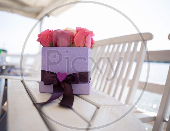 Box With Beautiful Pink Roses On The Table.