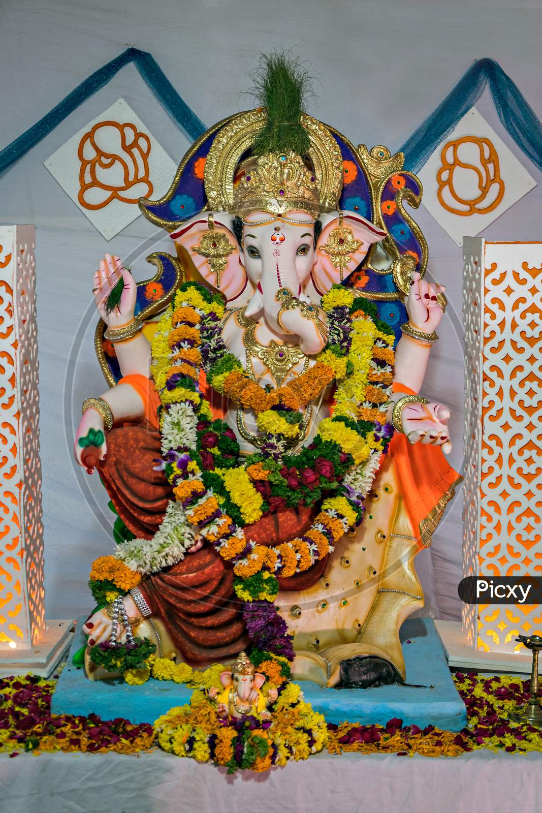 Portrait , closeup view of decorated and garlanded idol of Hindu God Ganesha in Pune, India.