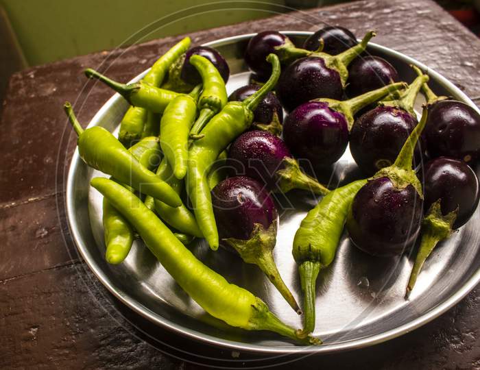 steel dish full of brinjal and green chillies