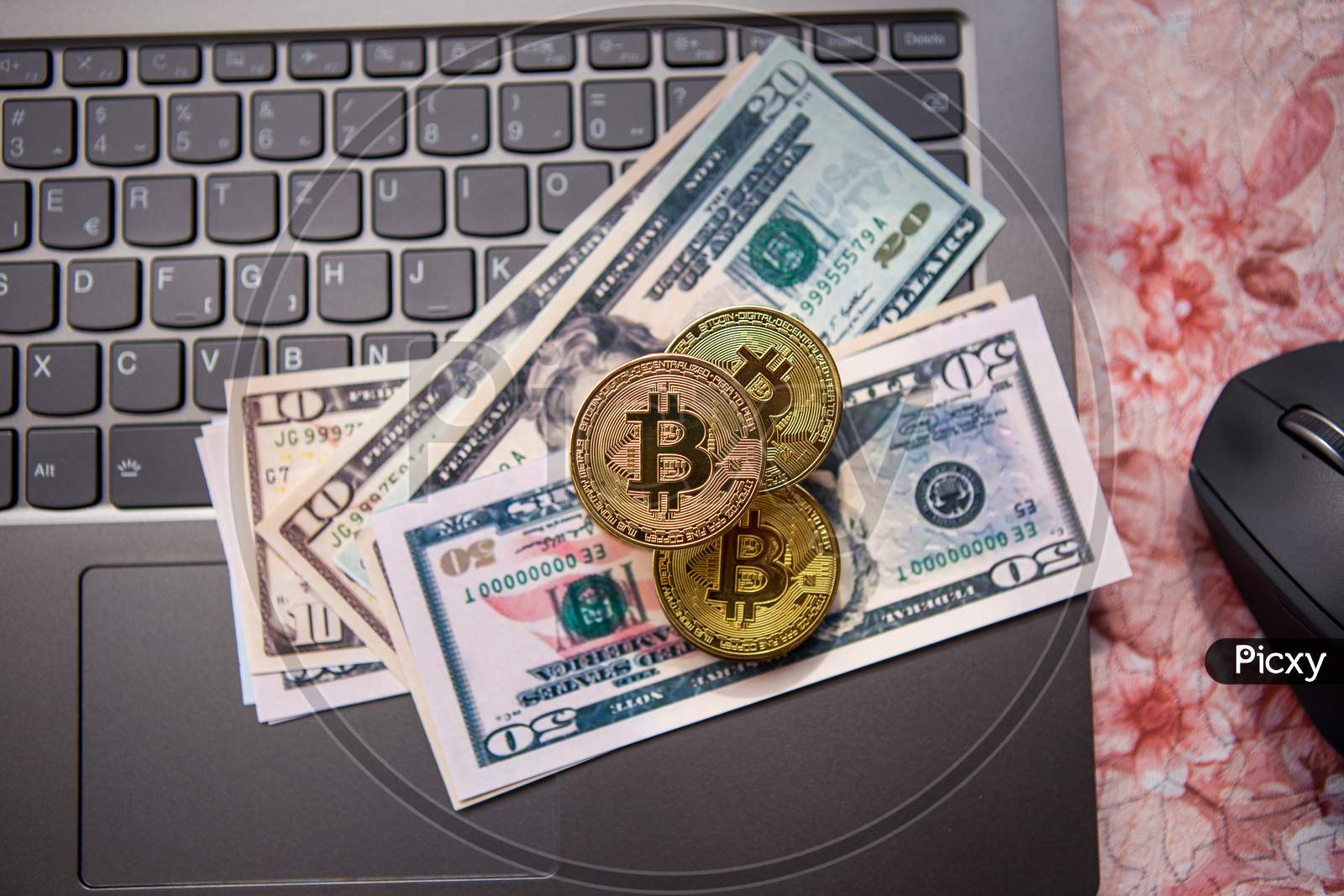 Bitcoin Gold Coins And Several Us Dollar Bills Are On A Laptop Keyboard.