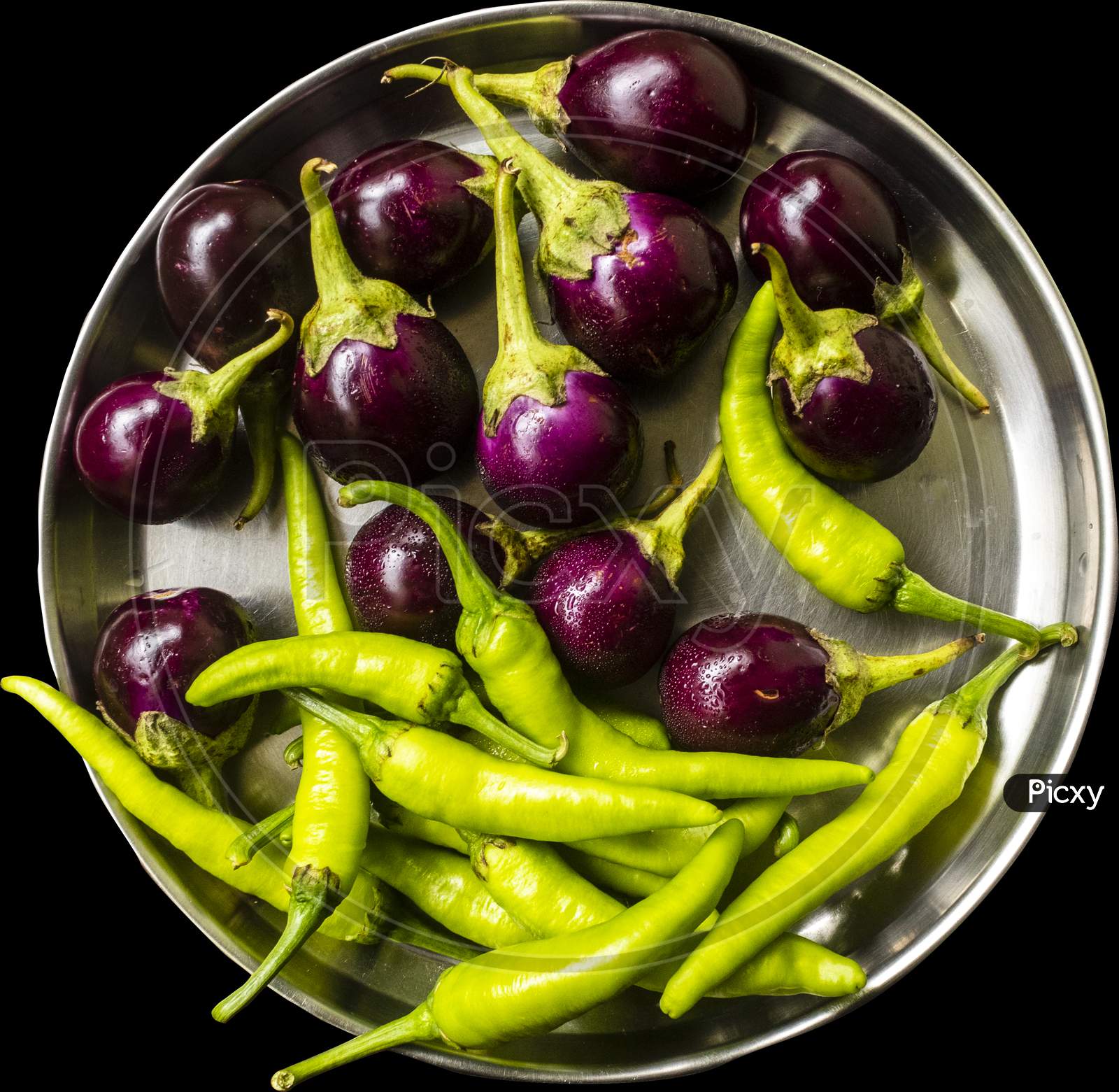 steel dish full of brinjal and green chillies, black background