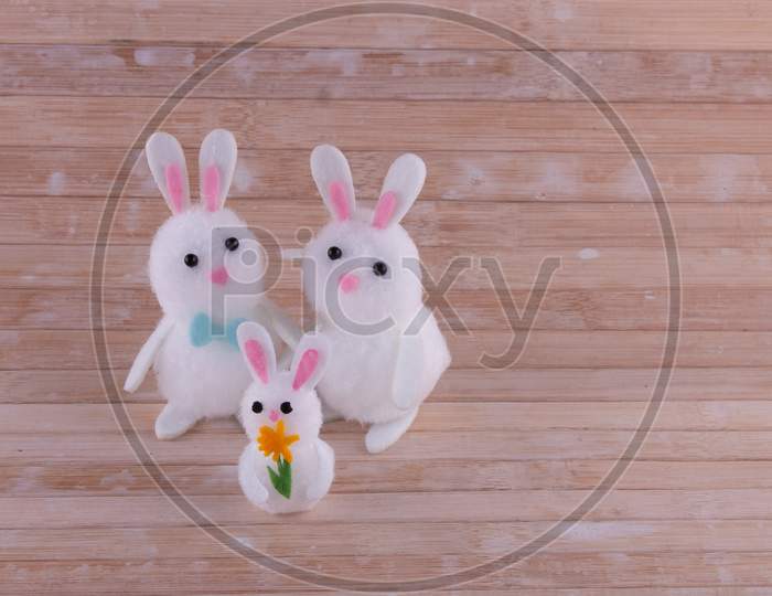 Cute Easter Bunny Family Of 3 Isolated On Wooden Background