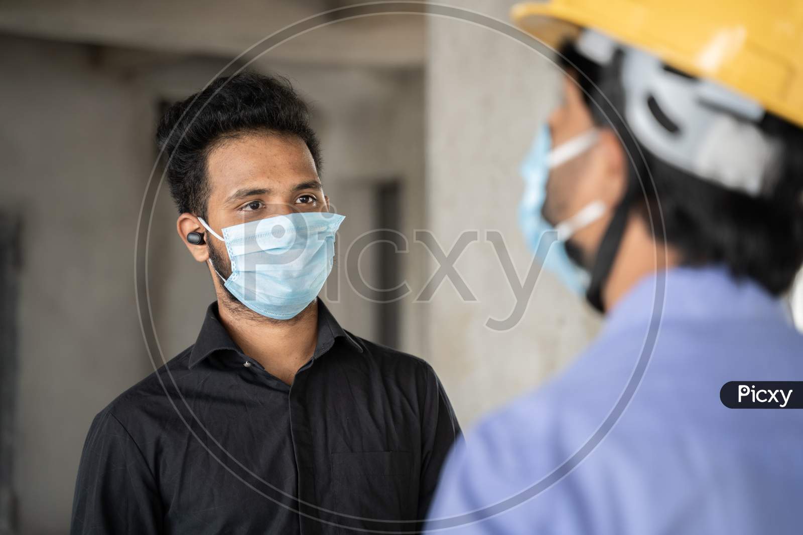 Shoulder Shot, Construction Worker And Engineer At Site Talking By Wearing Medical Mask With Social Distance - Concept Of Business, Industry Reopen And Covid-19 Safety Measures At Workplace.
