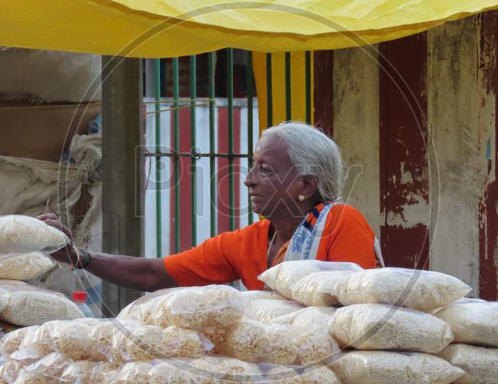 A Senior Old Woman Trading Purify Puffed Rice On The Road