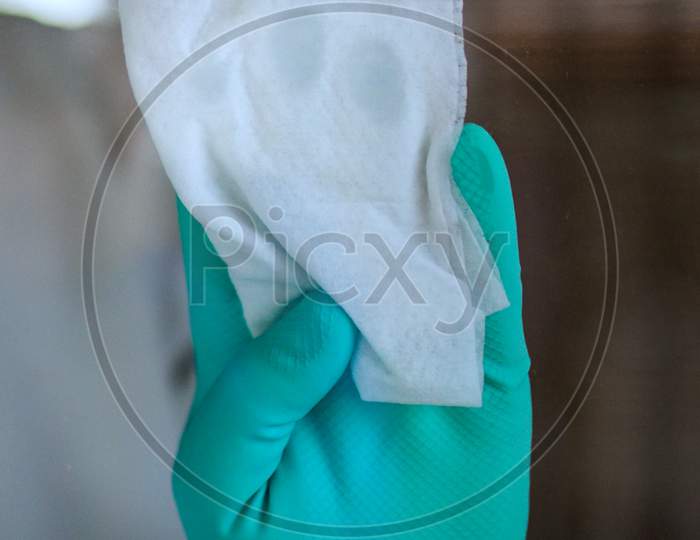 Women Clean Glass With Glove For Corona Virus