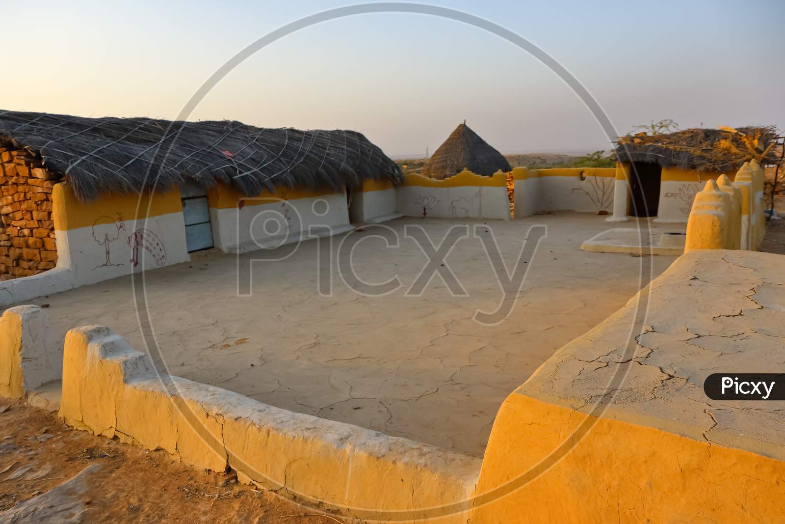 image of a mud house with thatched roof in an village in Rajasthan India