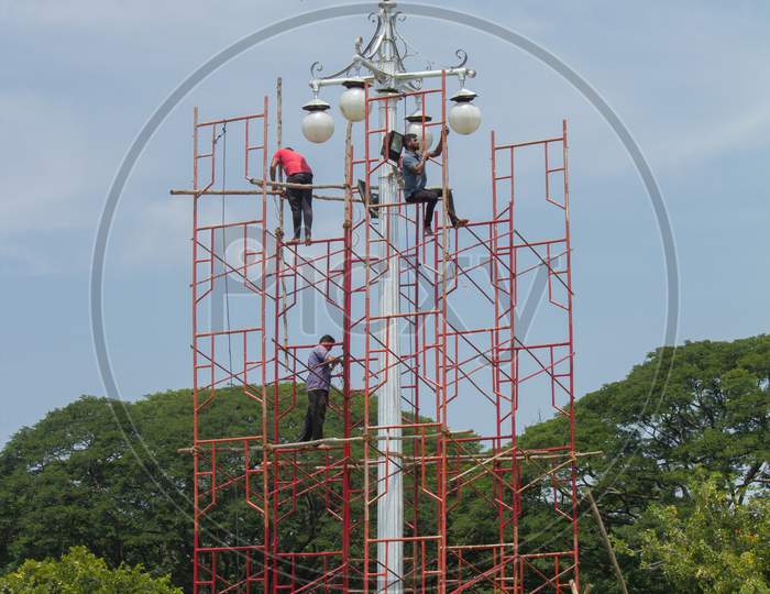 Electricians seen replacing the Bulbs on a High Lamp post inside Ambavilas Palace for the Dasara festival in Mysuru of Karnataka/India.