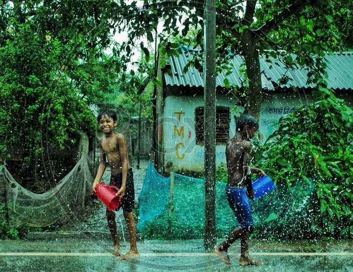 Children are playing with water in a rainy day