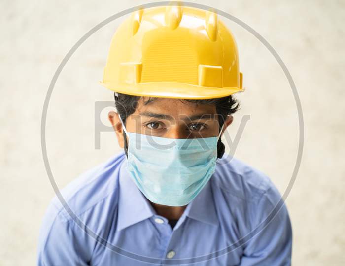 Hing Angle View Of Construction Worker In Medical Mask Looking Up In Confident - Concept Of Business, Industry Reopen And Covid-19 Safety Measures At Workplace.