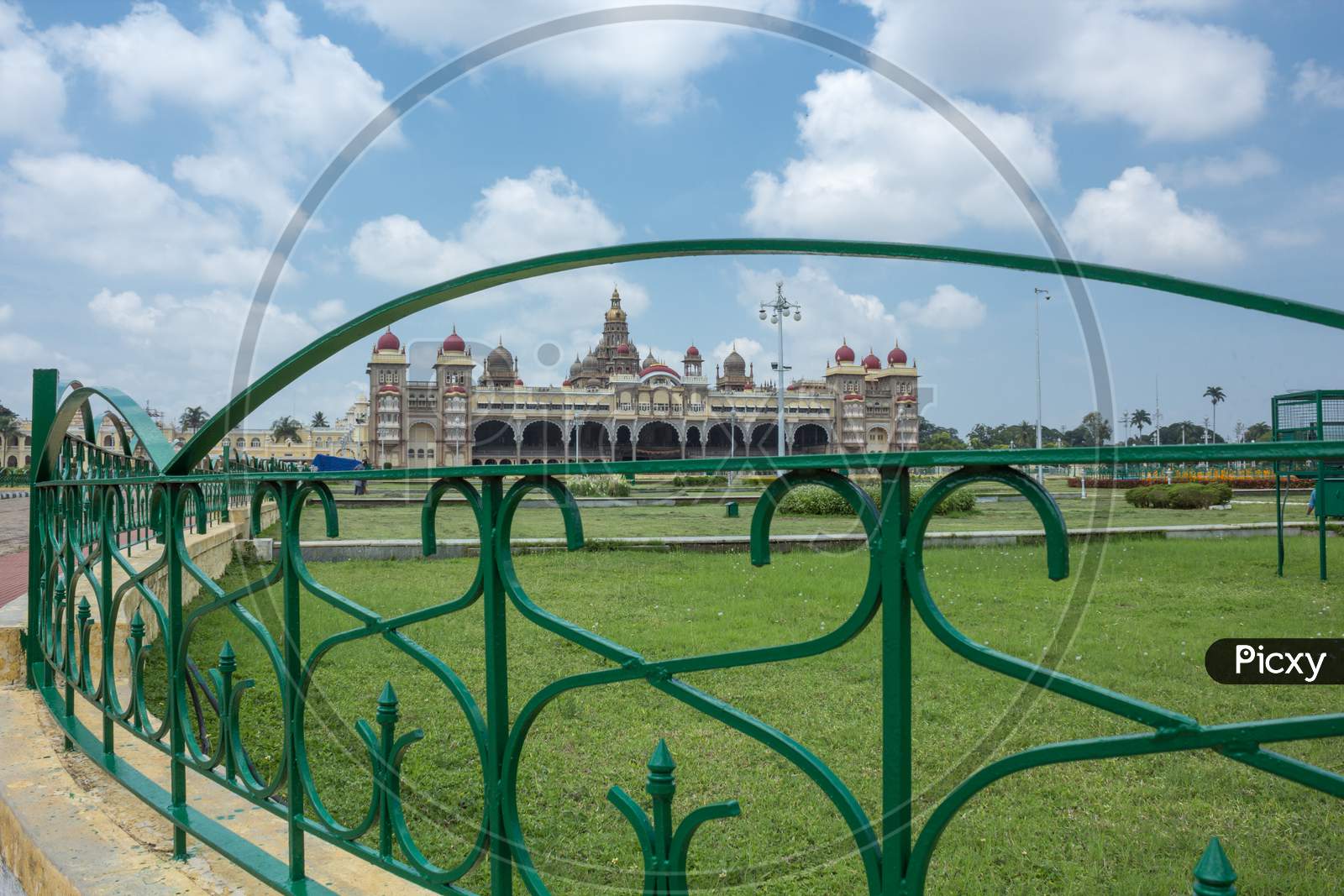 A Beautiful view of the Ambavilas Palace with the Clouds seen through the garden railing in Mysuru cityscape of Karnataka/India.