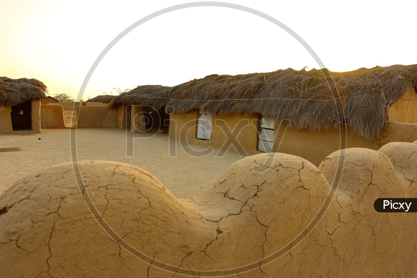 image of a mud house with thatched roof in an village in Rajasthan India