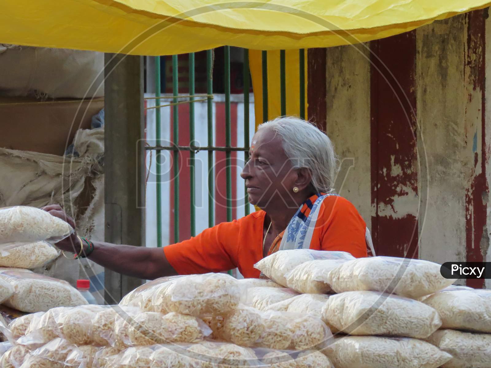A Senior Old Woman Trading Purify Puffed Rice On The Road