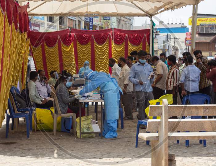 General Public are seen standing in a queue during Midday to get the Covid 19 test done  at a testing tent in Mysuru,Karnataka/India.