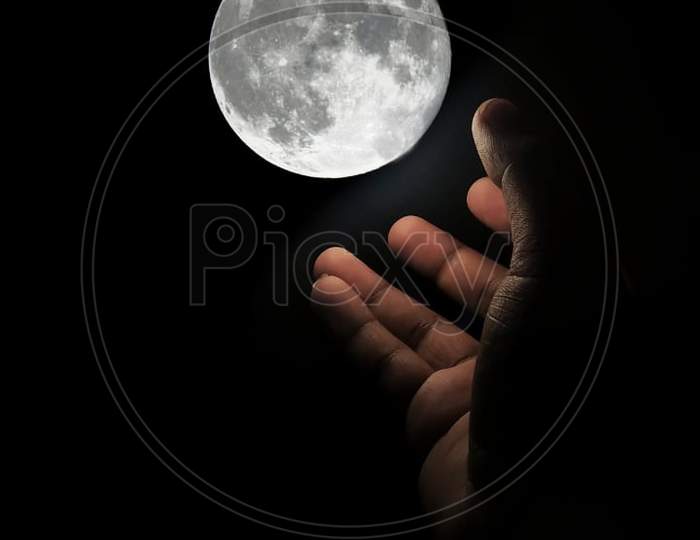Human hand finger to capture the moon