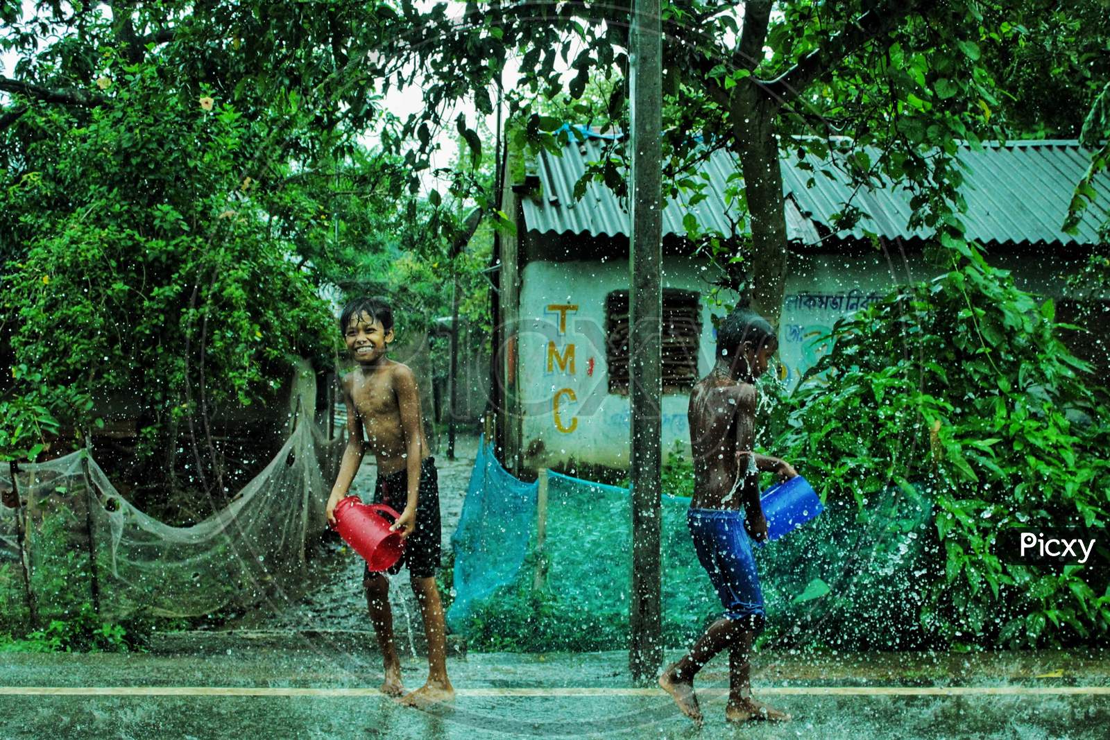 Children are playing with water in a rainy day