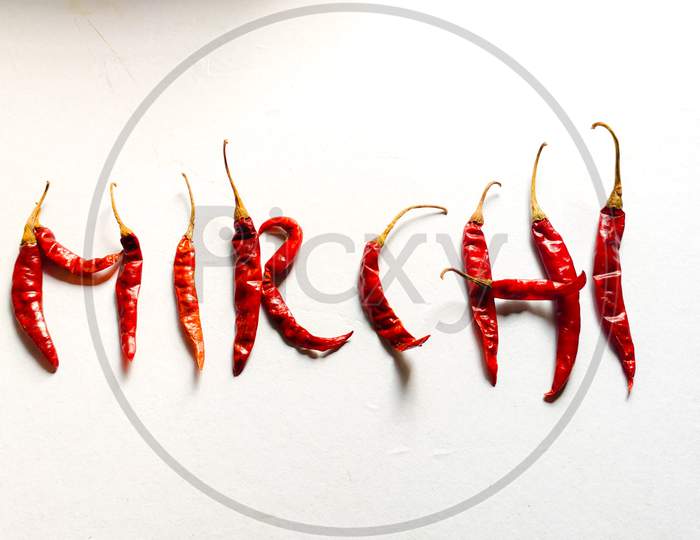 Red chilies with white background likes written "Mirchi" in Hindi.