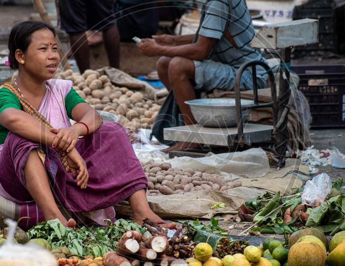 An unidentified woman vendor selling vegetables in weekly market