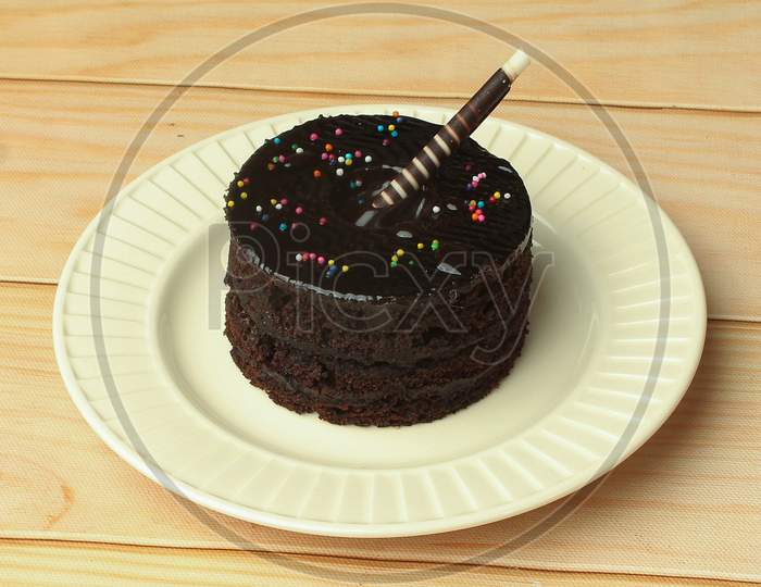 Tasty Dark Chocolate Cake On White Plate For Birthday Celebration
