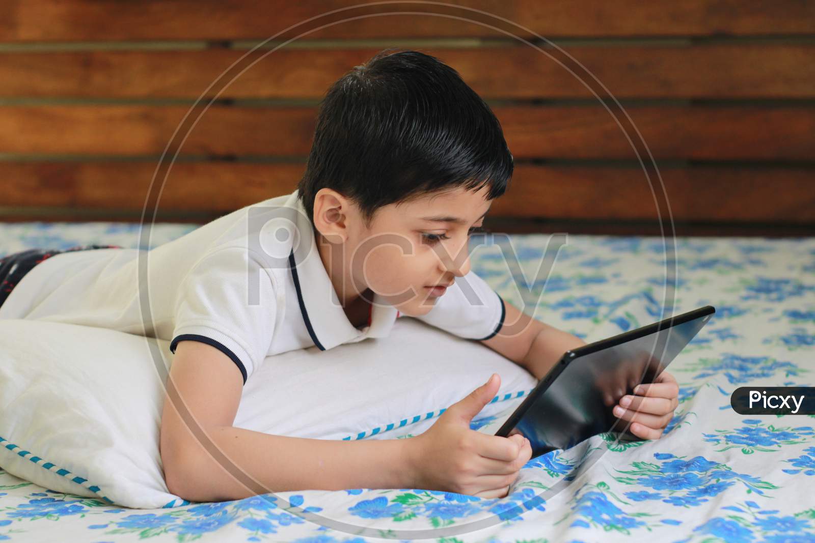Kid watching movie on Tablet pc. Kid playing on tablet pc. Kid at home during lock down