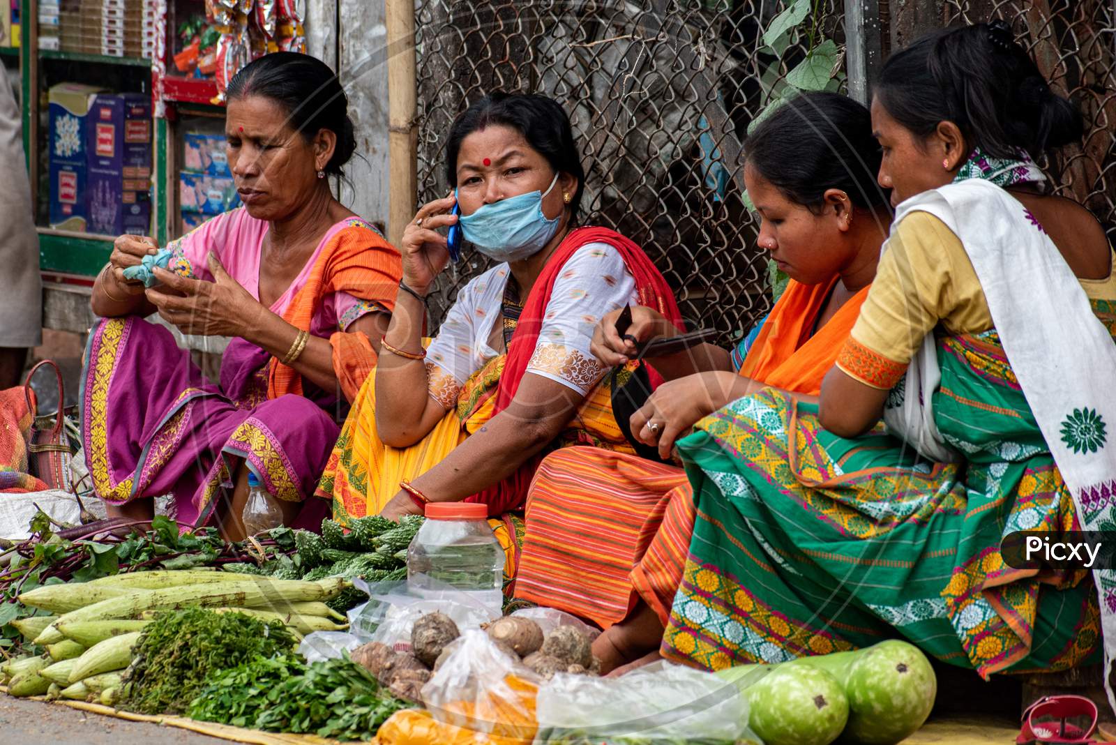 An unidentified woman vendor selling vegetables in weekly market