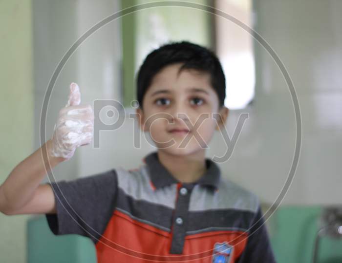 Asian Little Boy washing hands with water and soap. Hands Hygiene and virus infection prevention. Little boy explaining importance of washing hands with soap to prevent virus infection.