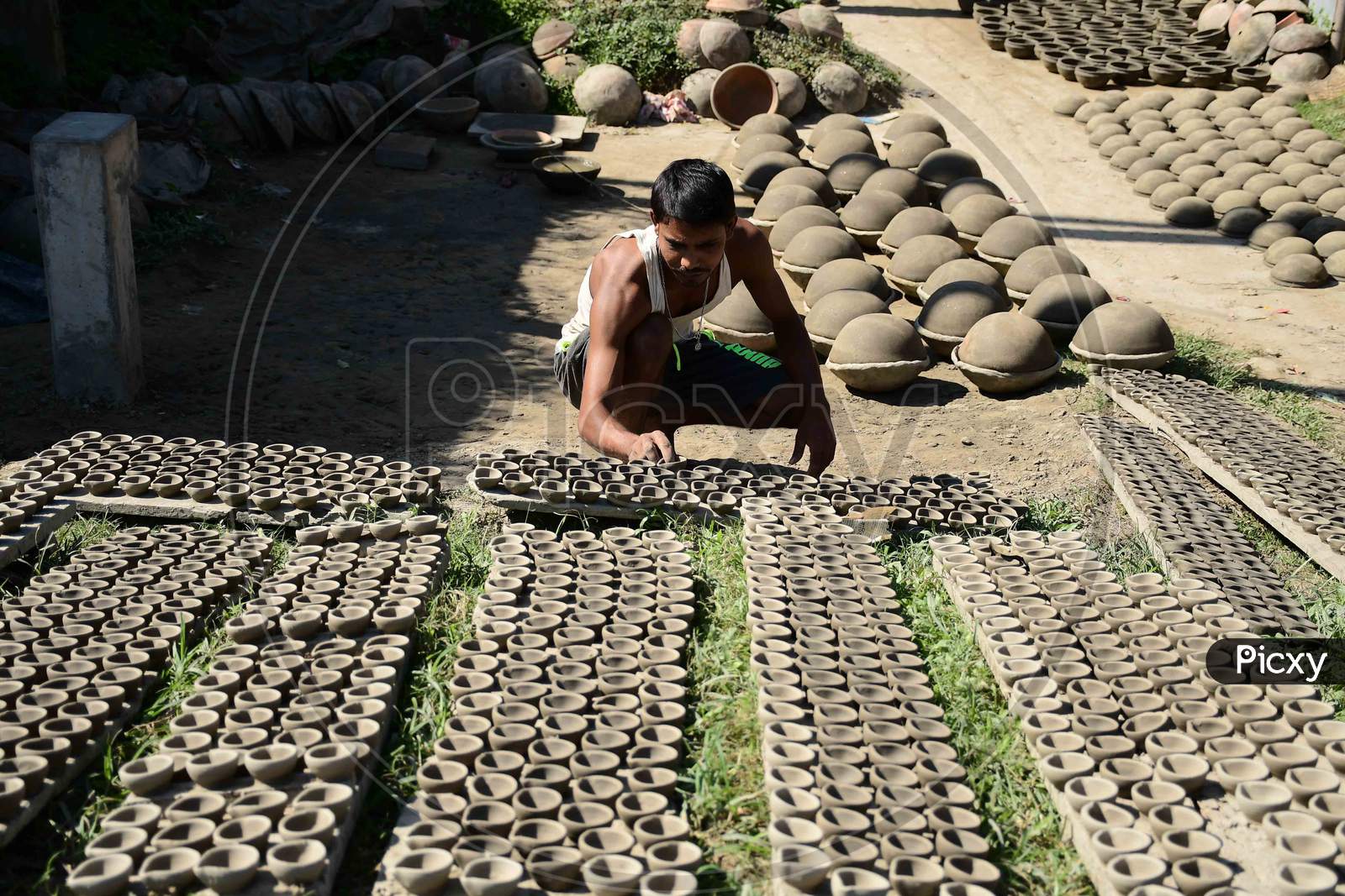 A  Potter arranging  earthen lamps being sun dried for upcoming Diwali festival at Rupohi village in Nagaon District of Assam on Nov 10,2020.
