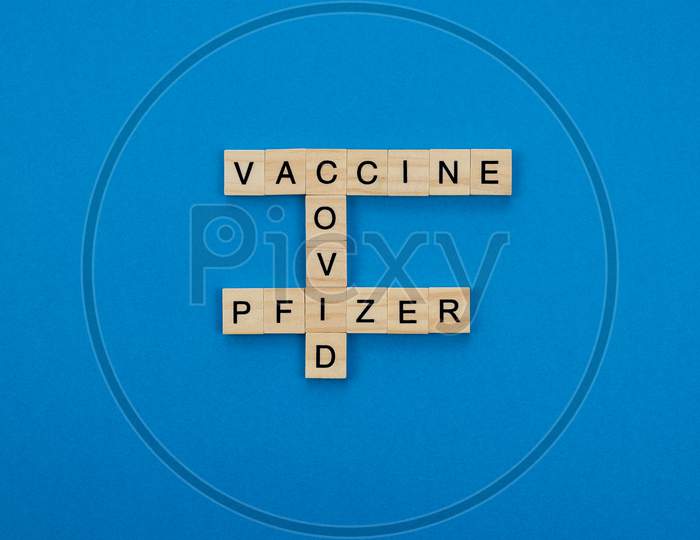 Vaccine 90% Effective Against The Coronavirus Pandemic Written With Wooden Letters On A Blue Background. Covid Concept.
