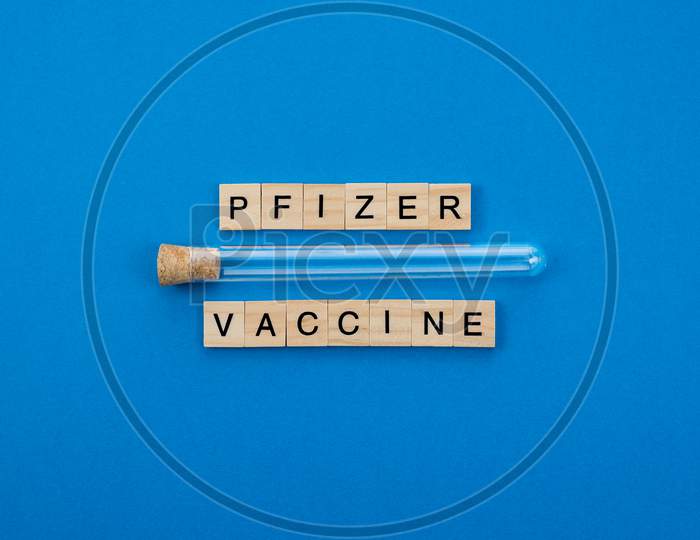 Vaccine 90% Effective Against The Coronavirus Pandemic Written With Wooden Letters On A Blue Background. Covid Concept.