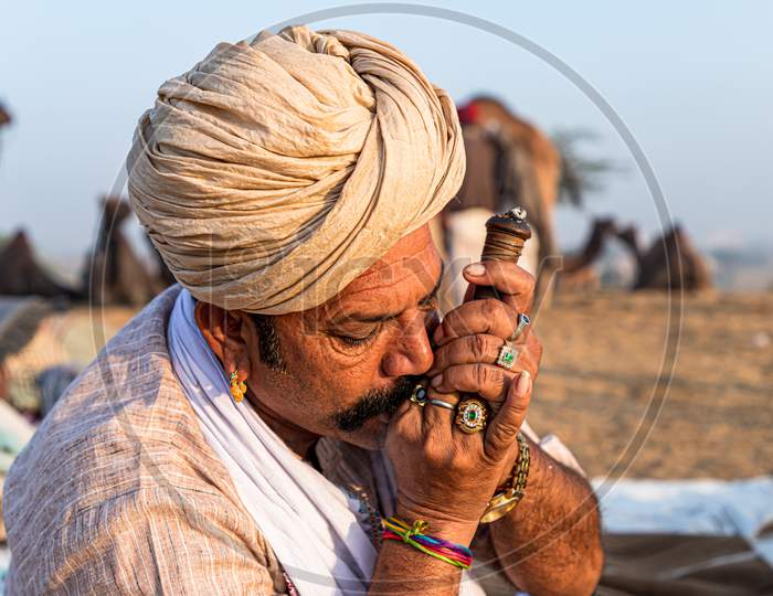A Rajasthani Tribal Man Smoking Chillam At Pushkar Camel Festival