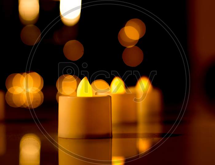 An Electric Candle emitting a soft golden light with a Bokeh effect against the dark background for the Diwali festival of Lights  Celebrated across India.
