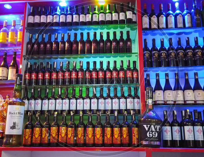 A Winsome view of Hard Liquor and Wine bottles arranged beautifully and lit with colorful lights at a True Spirit Store in Mysore/Karnataka/India.