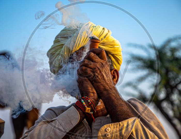 A Rajasthani Tribal Man Smoking Chillam At Pushkar