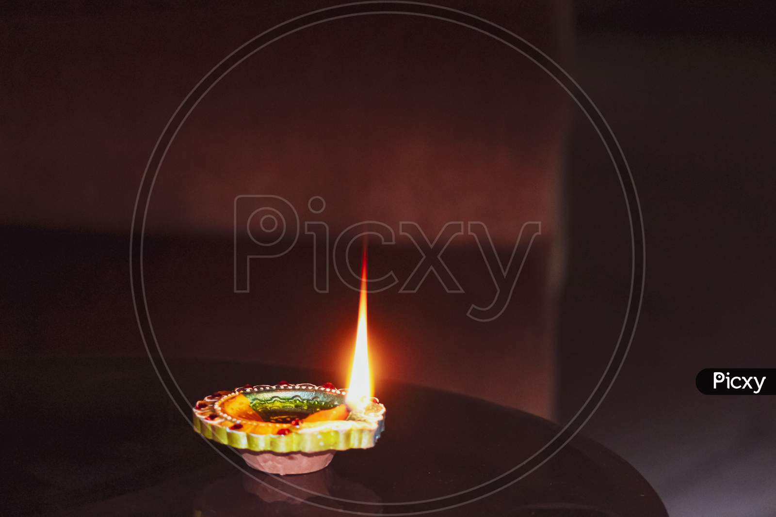 A burning oil small lamp flame in the dark for Diwali, Christmas, new year, celebration, occasion